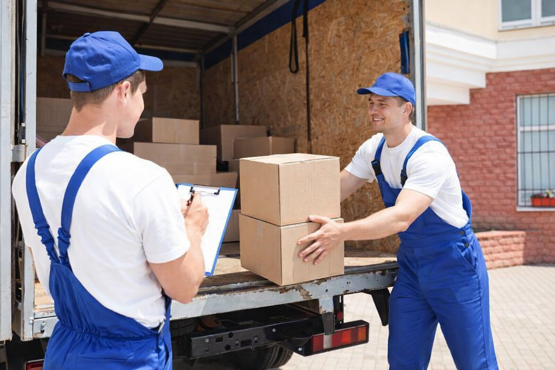 Грузчики загружают мебель в авто